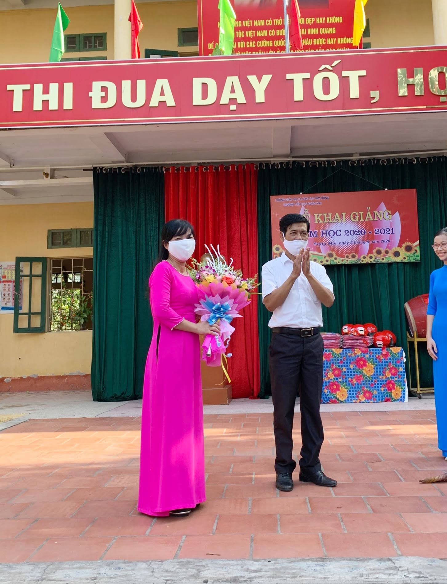 Ông Nguyễn Văn Xuyên - UV ban thường vụ, chủ tịch Mặt trận Tổ quốc xã Song Mai tặng hoa thày và trò nhà trường trong lễ khai giảng